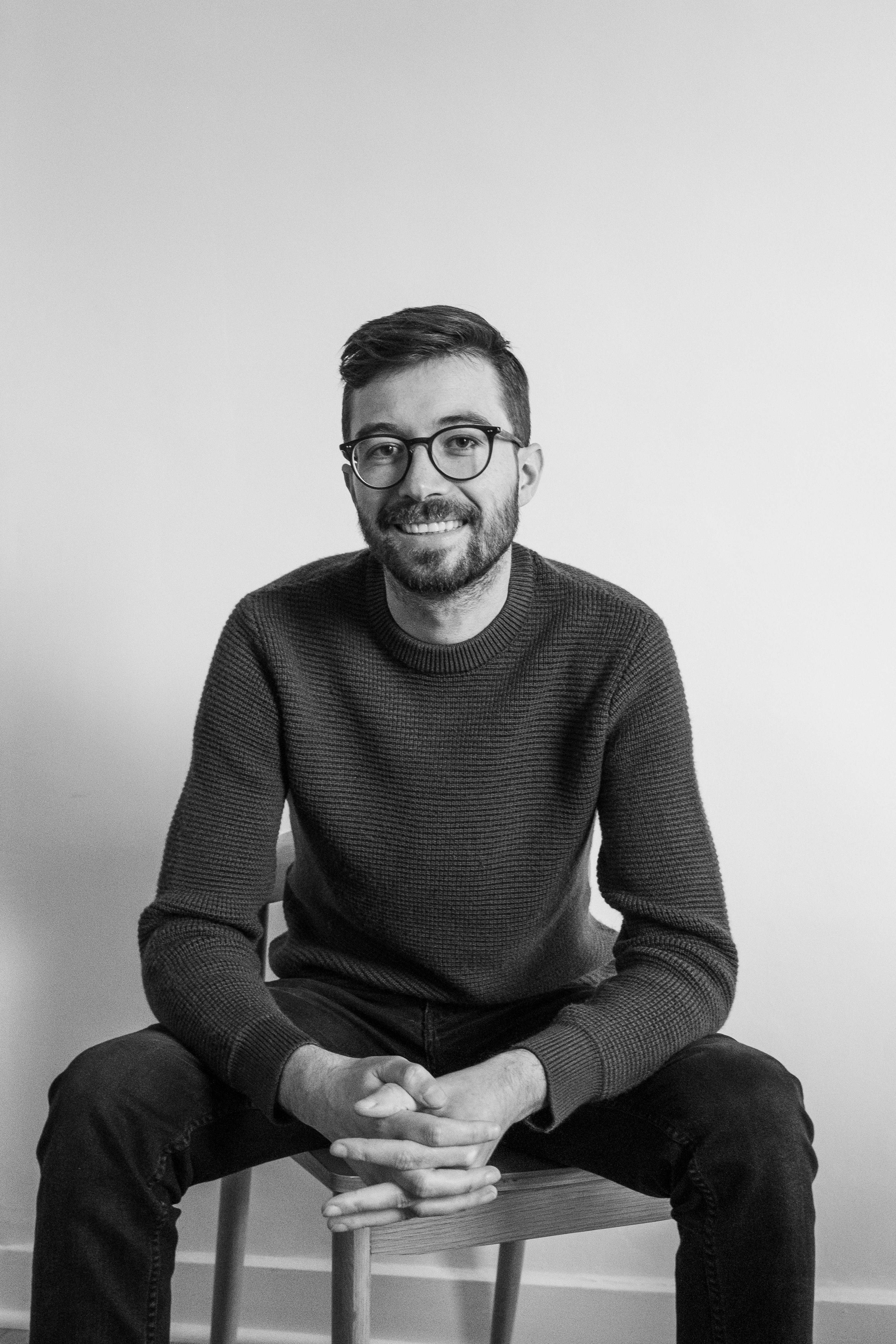 David Barbier's freelance web developer portrait sitting on a chair and smiling